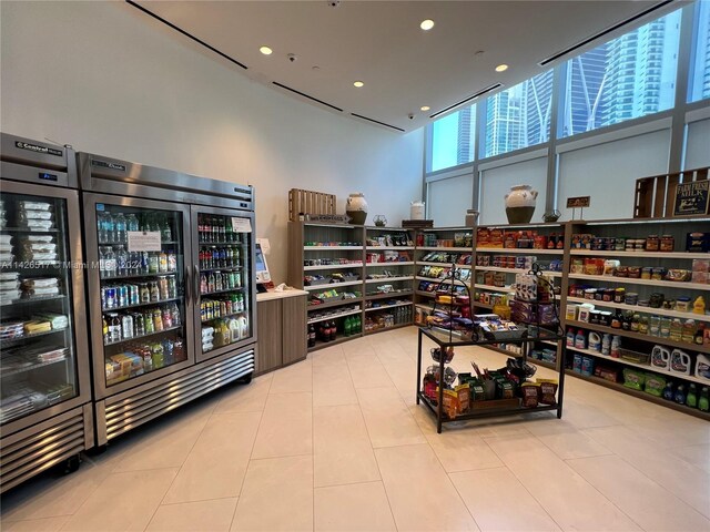 interior space featuring light tile patterned floors, wine cooler, and a high ceiling