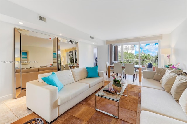 living area featuring a wall of windows, recessed lighting, visible vents, and light tile patterned floors