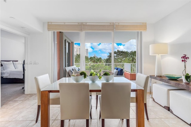 dining room with light tile patterned floors and a wall of windows