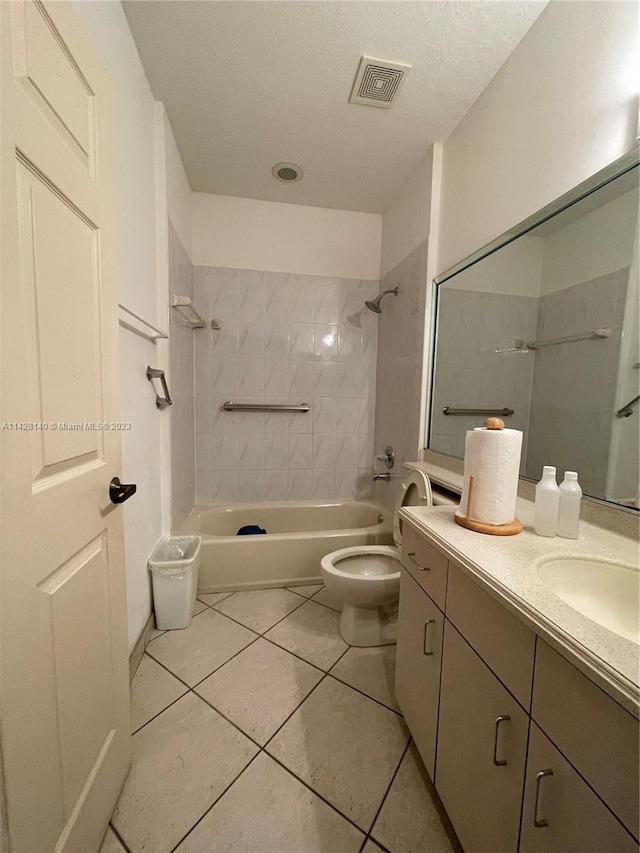 full bathroom with toilet, vanity with extensive cabinet space, tiled shower / bath, tile floors, and a textured ceiling