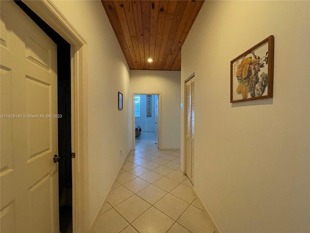 hallway with light tile floors and wooden ceiling