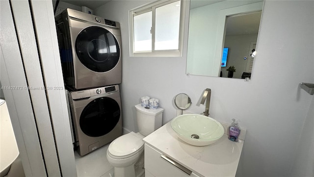 clothes washing area featuring stacked washing maching and dryer and sink