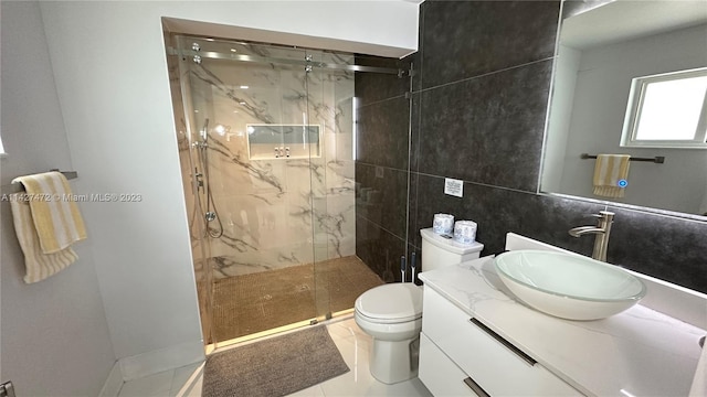 bathroom featuring toilet, a shower with shower door, vanity, tile walls, and tile flooring