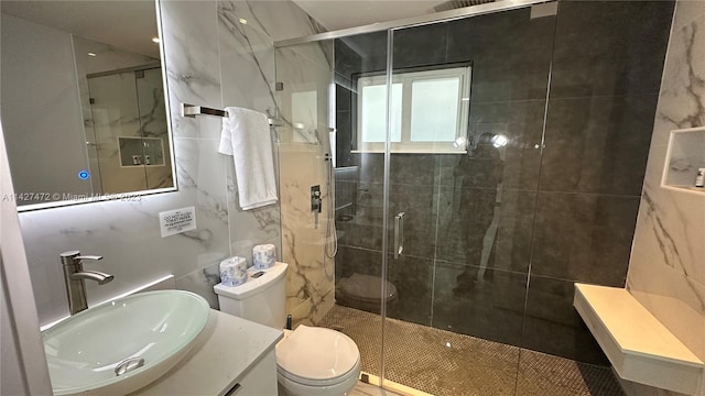 bathroom featuring walk in shower, large vanity, toilet, and tile walls