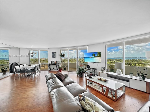 living room featuring floor to ceiling windows, a chandelier, and light hardwood / wood-style floors