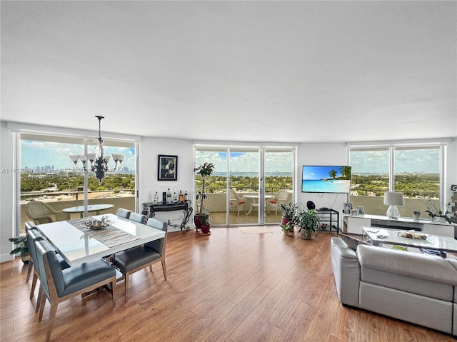 living room featuring plenty of natural light, a notable chandelier, and light wood-type flooring