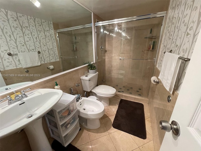 bathroom featuring tile walls, toilet, a bidet, an enclosed shower, and tile floors