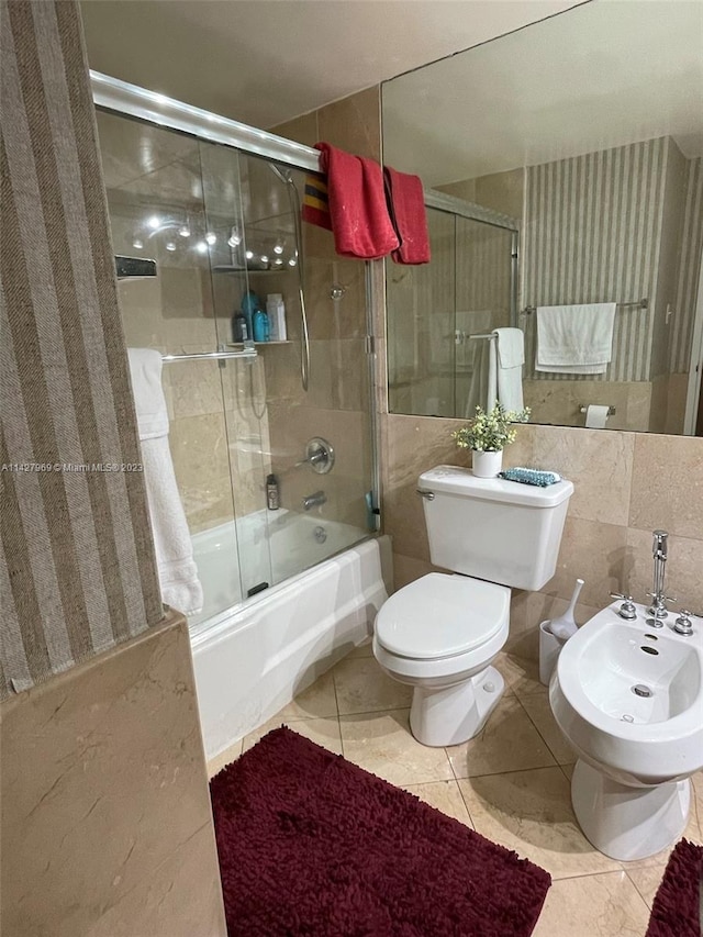 bathroom with tile walls, toilet, a bidet, enclosed tub / shower combo, and tile floors