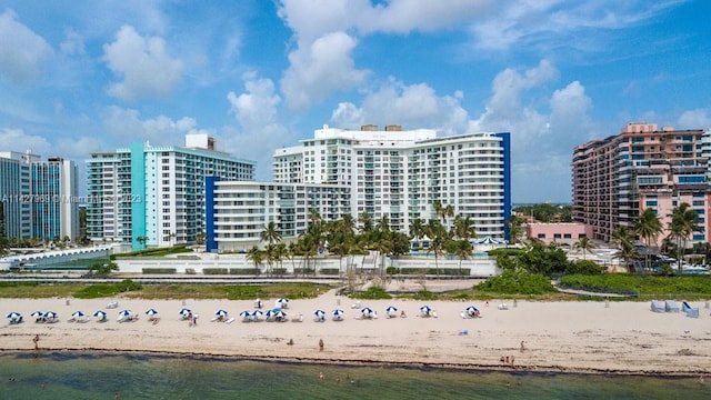 view of building exterior with a water view and a view of the beach