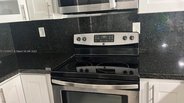 kitchen with white cabinets, tasteful backsplash, dark stone countertops, and stainless steel electric stove