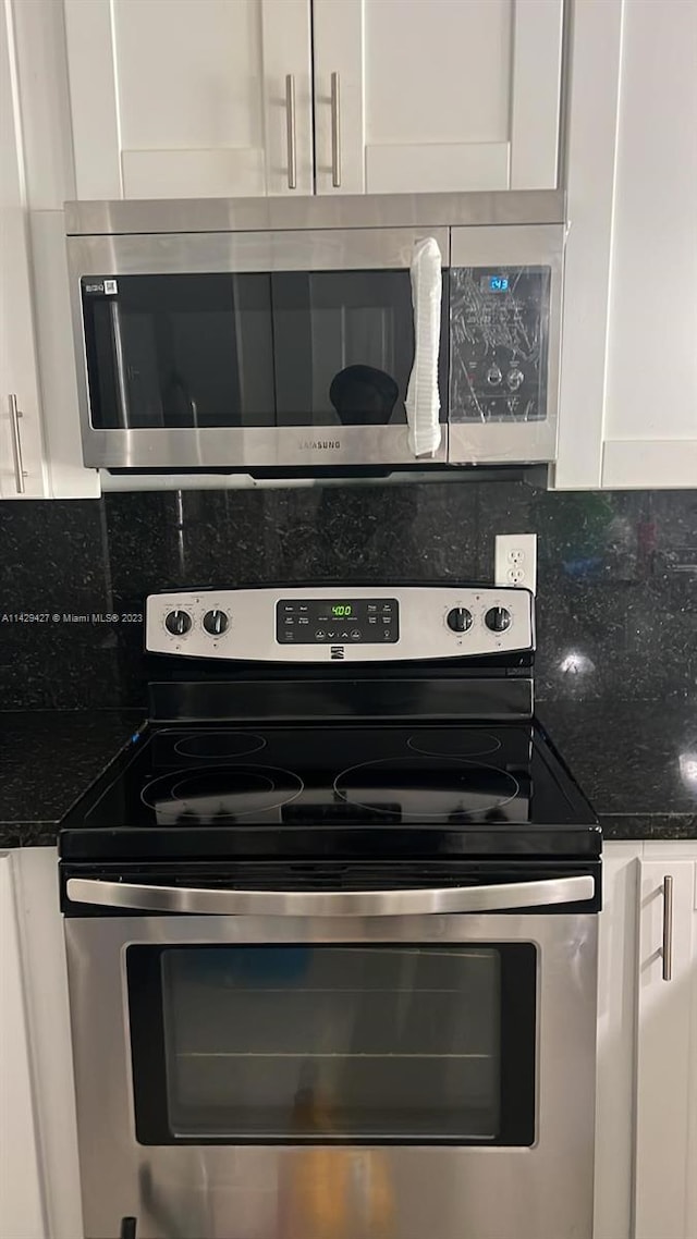 kitchen with white cabinets, backsplash, and stainless steel appliances