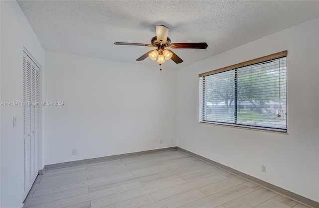 unfurnished room with light wood-type flooring, ceiling fan, and a textured ceiling