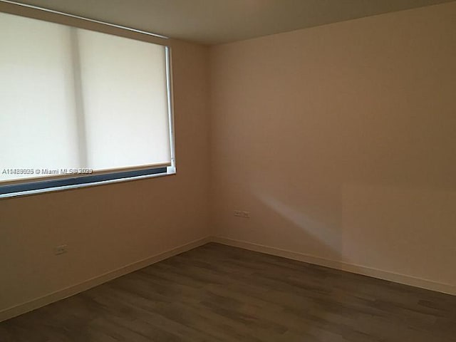 unfurnished room with dark hardwood / wood-style flooring