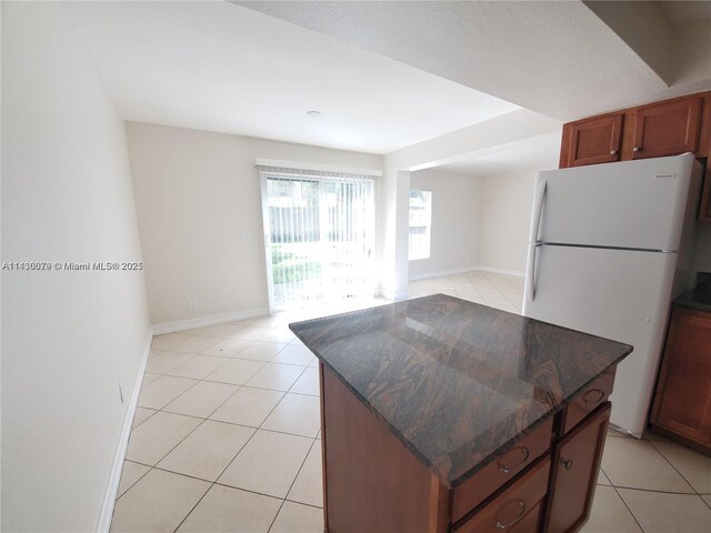 kitchen featuring sink, black appliances, a center island, and light tile patterned flooring