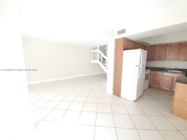 kitchen with sink, light tile patterned floors, and white appliances