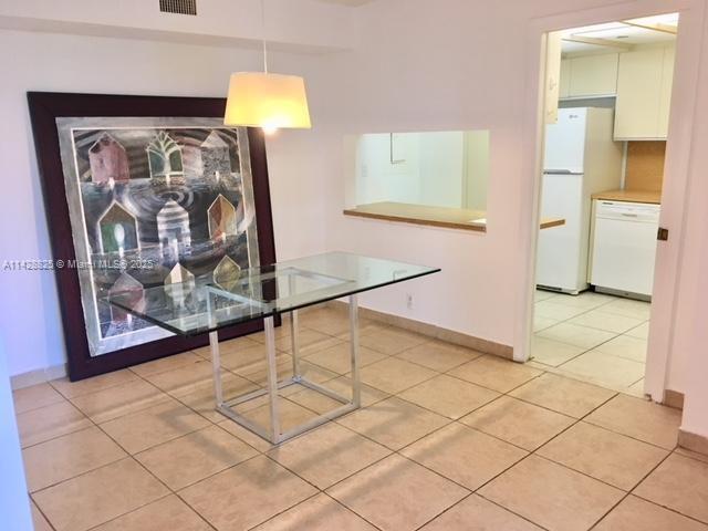 unfurnished dining area featuring light tile patterned floors, visible vents, and baseboards