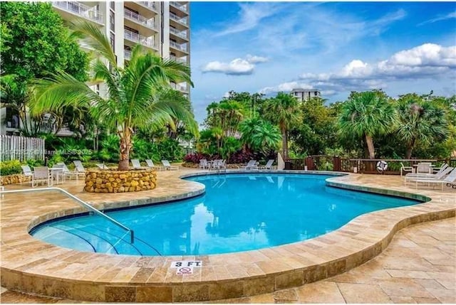 community pool featuring a patio area and fence