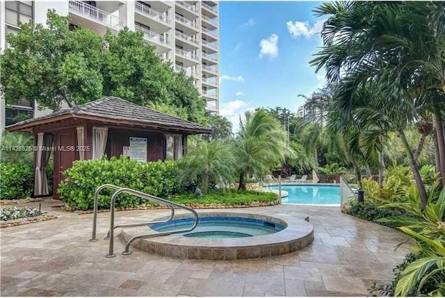 community pool featuring a community hot tub, a patio area, and a gazebo