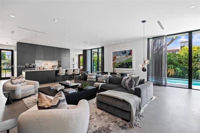 living room with a wealth of natural light, sink, and expansive windows