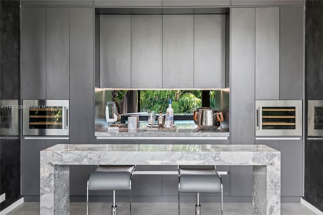 kitchen featuring gray cabinetry and light stone countertops