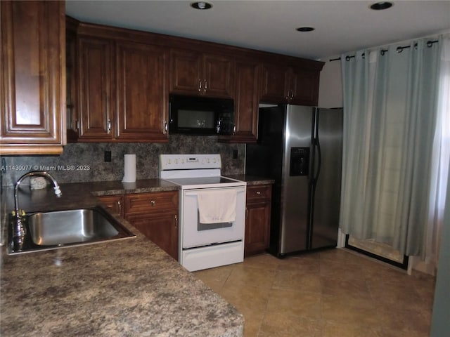 kitchen featuring stainless steel refrigerator with ice dispenser, dark countertops, white electric range, a sink, and black microwave