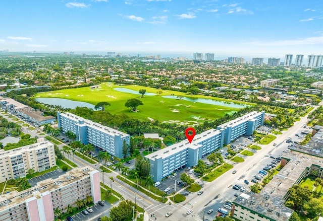 drone / aerial view with a water view, a city view, and golf course view