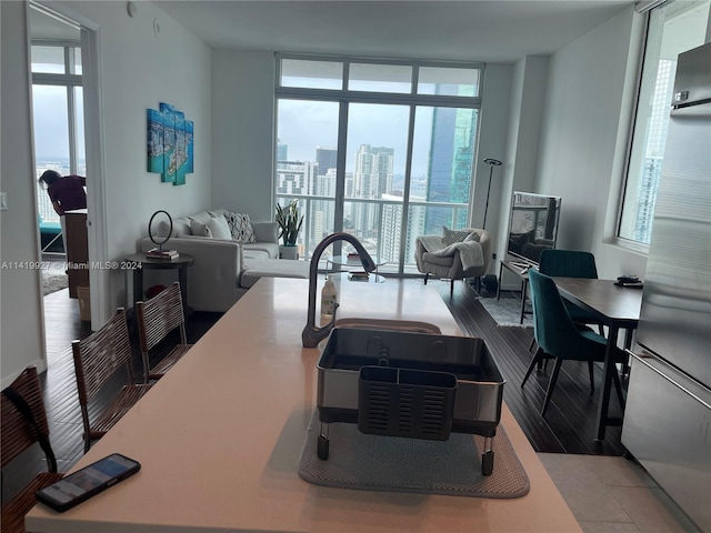 kitchen featuring sink, stainless steel refrigerator, and a wall of windows