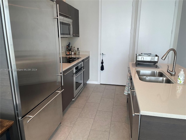 kitchen featuring sink, appliances with stainless steel finishes, and light tile patterned floors