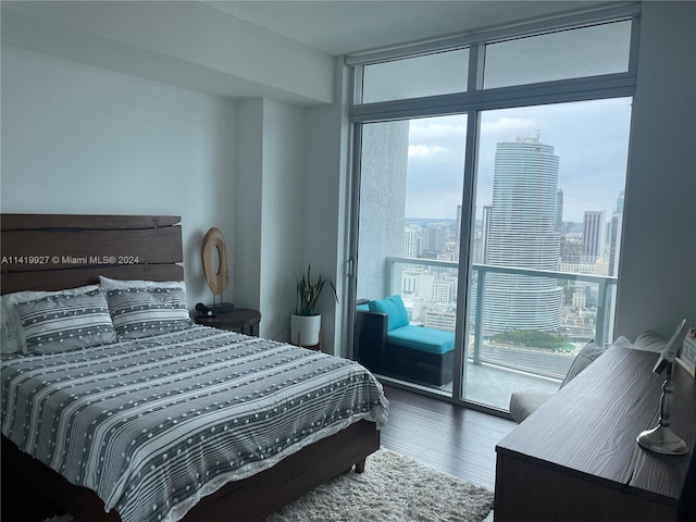 bedroom featuring multiple windows, access to exterior, a wall of windows, and dark hardwood / wood-style floors