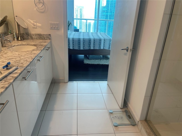 bathroom featuring tile patterned flooring, vanity, and a shower with shower door