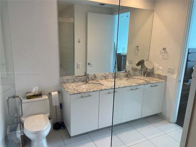 bathroom with an enclosed shower, vanity, tile patterned flooring, and toilet