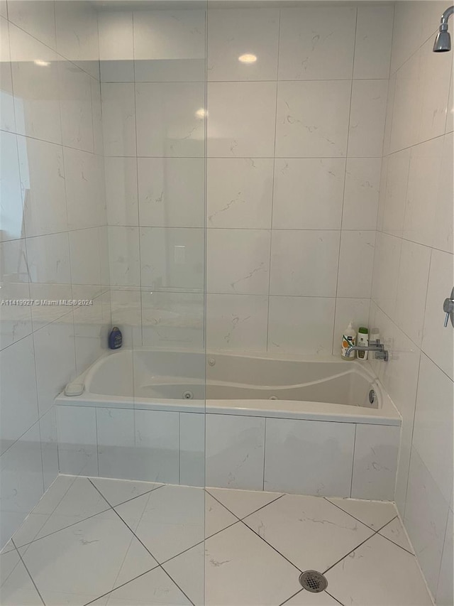 bathroom with tile walls and tiled shower / bath