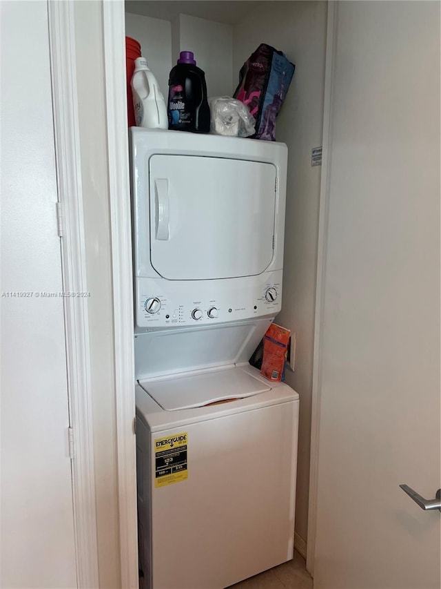 clothes washing area featuring stacked washer and clothes dryer