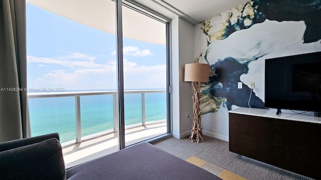 bedroom featuring a water view, expansive windows, and access to outside