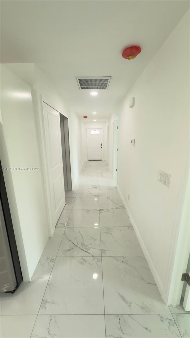 hall featuring baseboards, visible vents, and marble finish floor