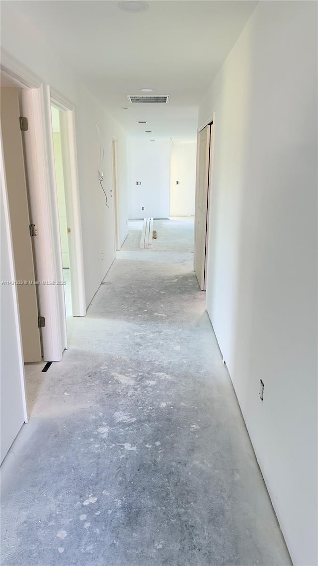 hallway with unfinished concrete flooring and visible vents