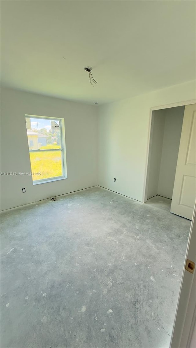 unfurnished bedroom featuring concrete flooring