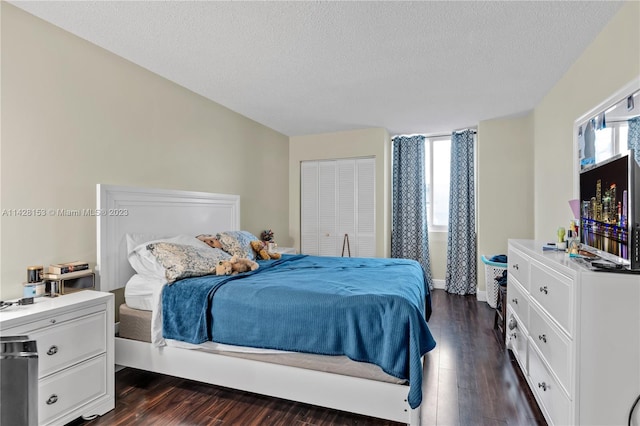 bedroom featuring a textured ceiling, dark hardwood / wood-style flooring, and a closet