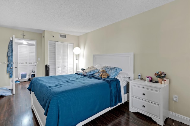 bedroom featuring a closet, dark wood-type flooring, and a textured ceiling