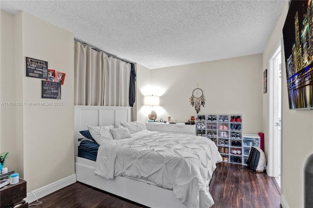 bedroom featuring a textured ceiling and dark hardwood / wood-style flooring