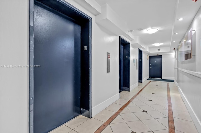 hallway featuring light tile floors and elevator