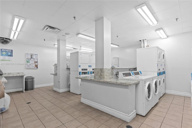 washroom featuring light tile floors, washer and clothes dryer, and stacked washer and clothes dryer