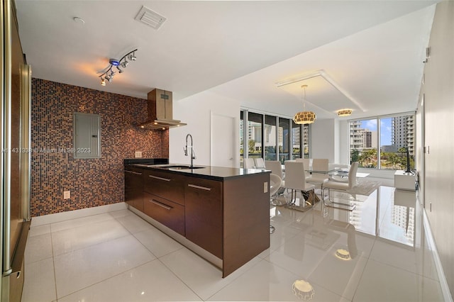 kitchen with light tile floors, ventilation hood, dark brown cabinets, sink, and track lighting