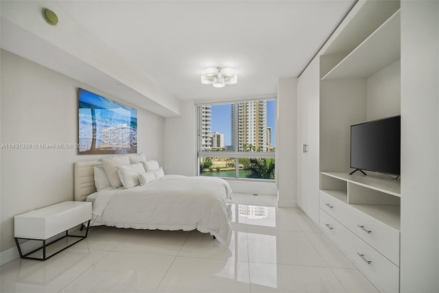 bedroom featuring light tile flooring and a notable chandelier