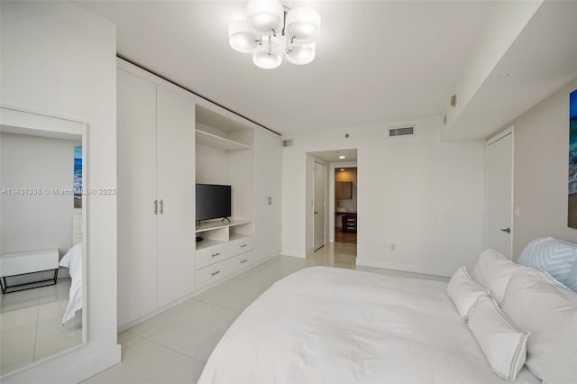 bedroom featuring light tile floors and an inviting chandelier