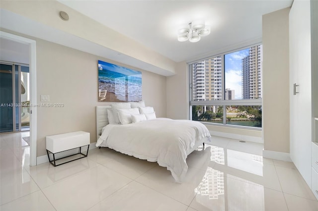 bedroom featuring light tile flooring and a notable chandelier