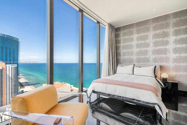 bedroom with floor to ceiling windows and a water view