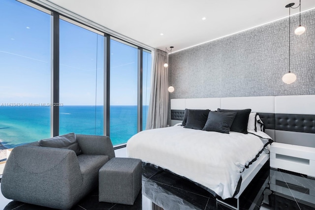 bedroom featuring expansive windows and a water view