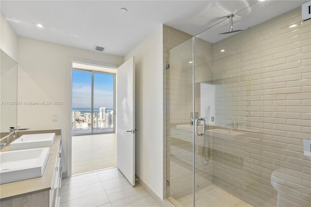 bathroom with double sink vanity, tile floors, and a shower with door