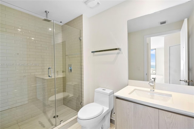 bathroom with toilet, large vanity, and a shower with shower door